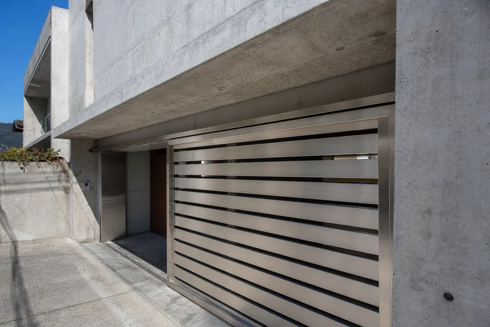 Reinforced concrete entrance with a heavy sliding steel gate in daylight