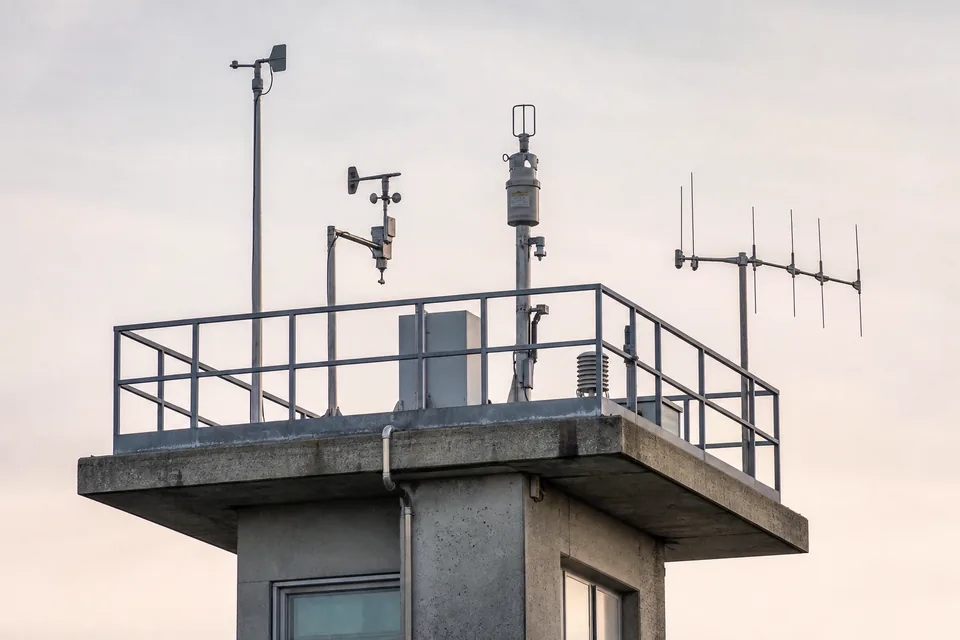 Weather observation deck on a concrete tower with instruments against a pale sky